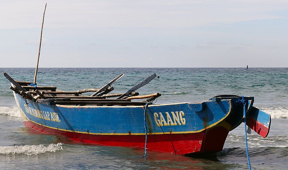 A blue fishing boat on the shore in Ilocos Norte